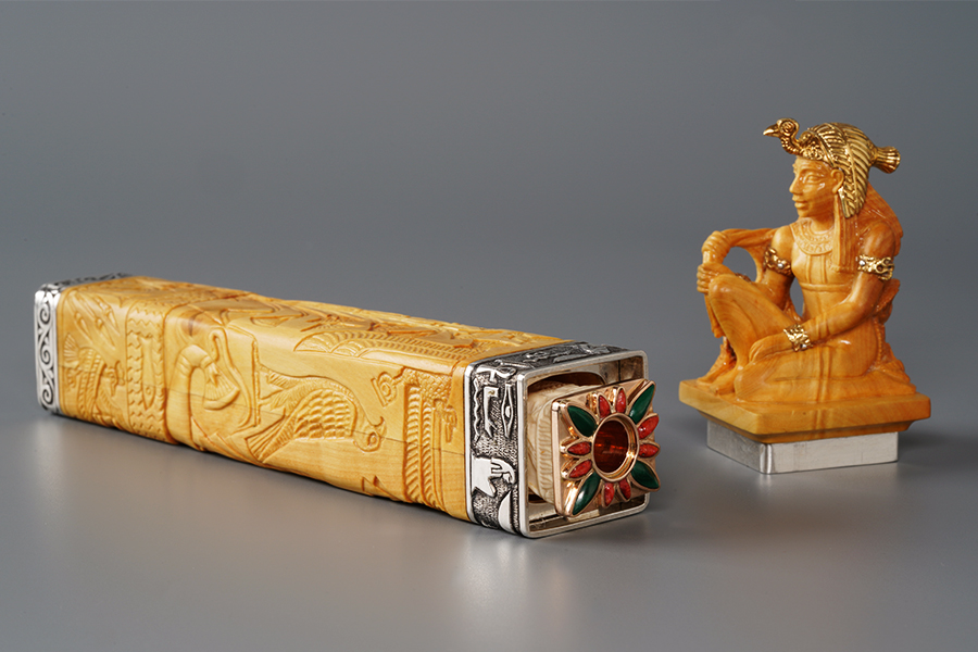Gold, art carved bone, coral and malachite cigarette holder in its original case